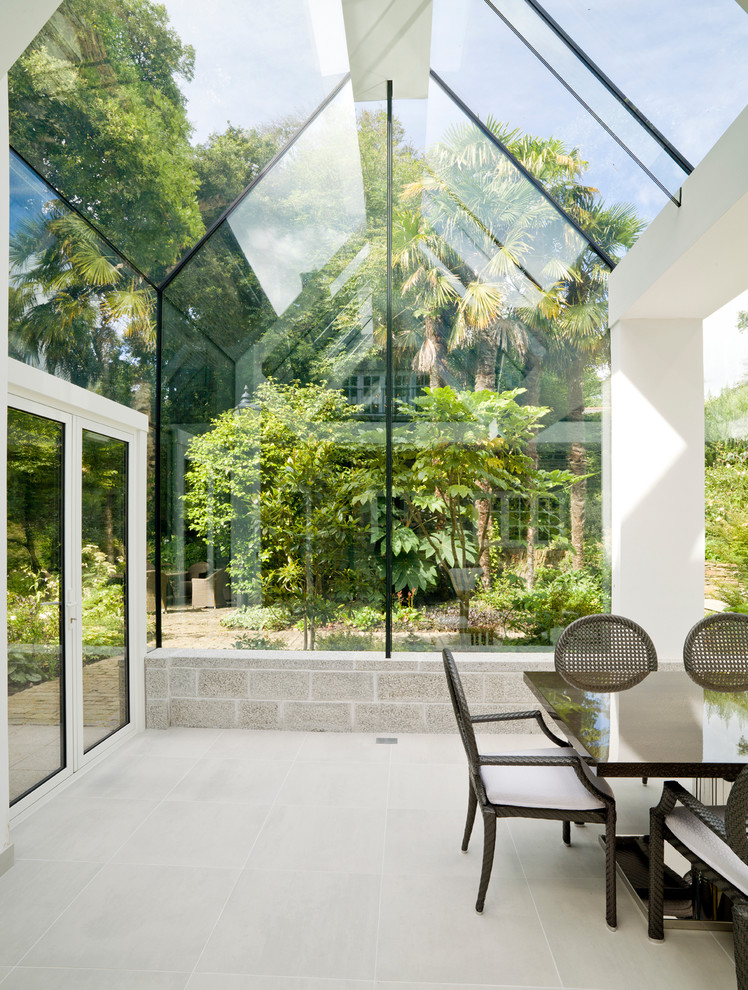Ispirazione per una grande veranda design con pavimento in pietra calcarea, soffitto in vetro e pavimento beige