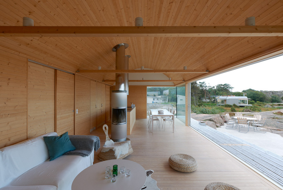 Immagine di un'ampia veranda scandinava con parquet chiaro e camino classico