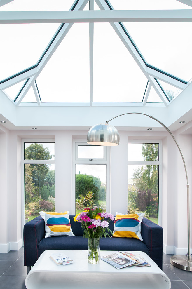 Immagine di una veranda contemporanea con nessun camino, soffitto in vetro e pavimento grigio