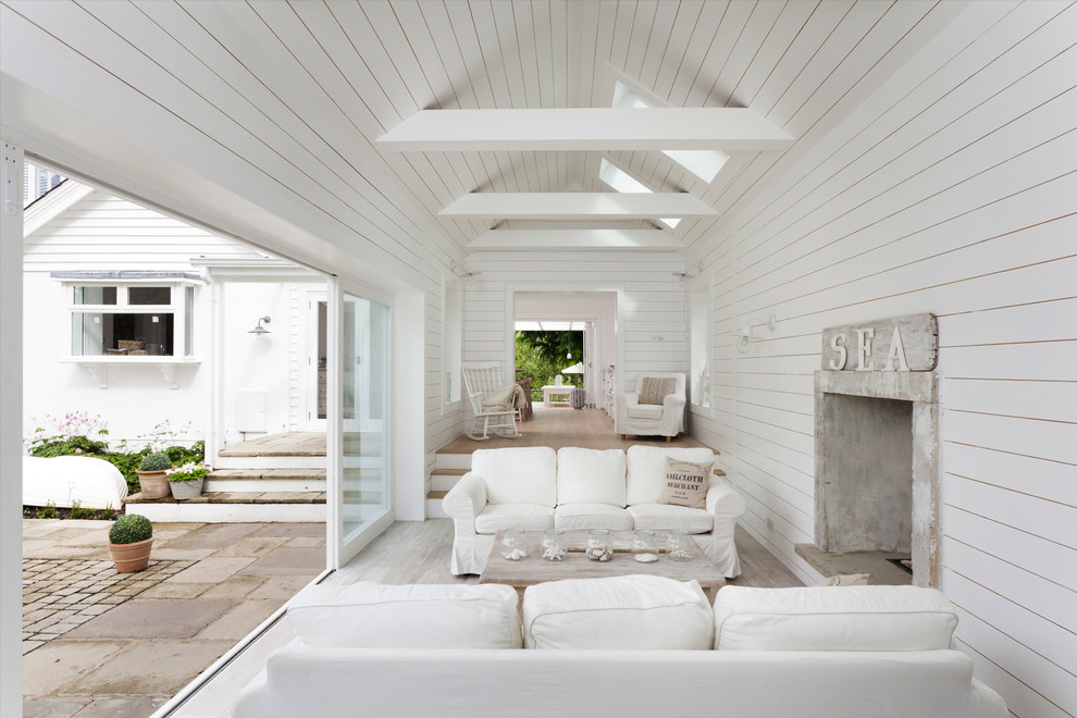 Esempio di una veranda stile marinaro con parquet chiaro e camino classico