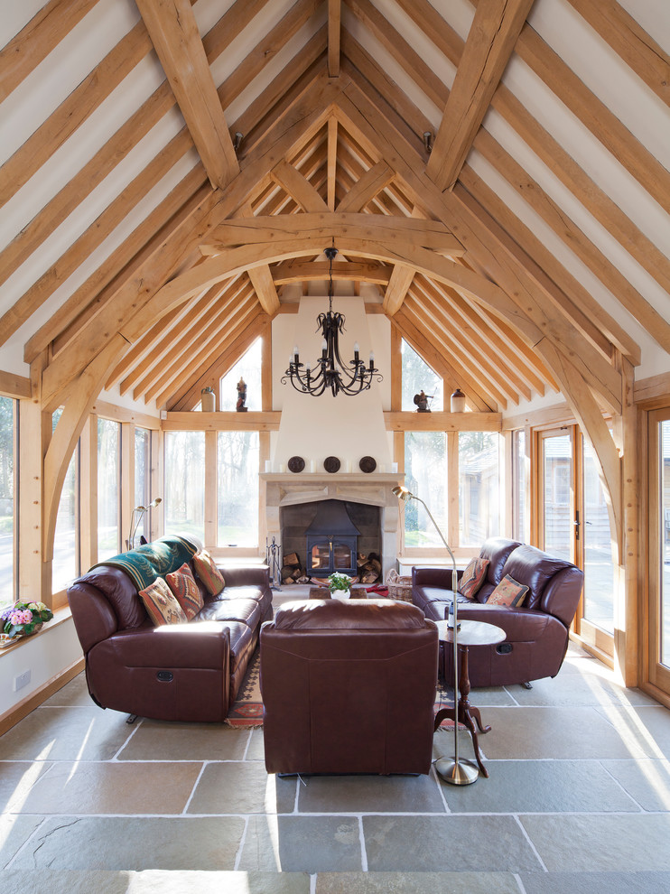 Foto di una veranda country con stufa a legna, pavimento grigio e soffitto classico