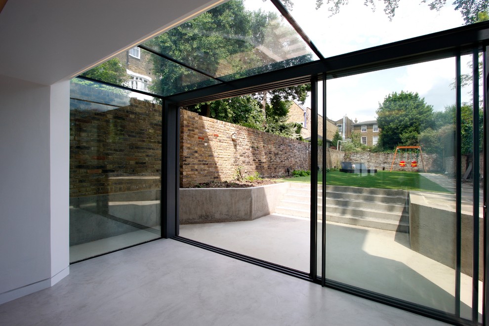Ispirazione per una piccola veranda contemporanea con pavimento in pietra calcarea e soffitto in vetro