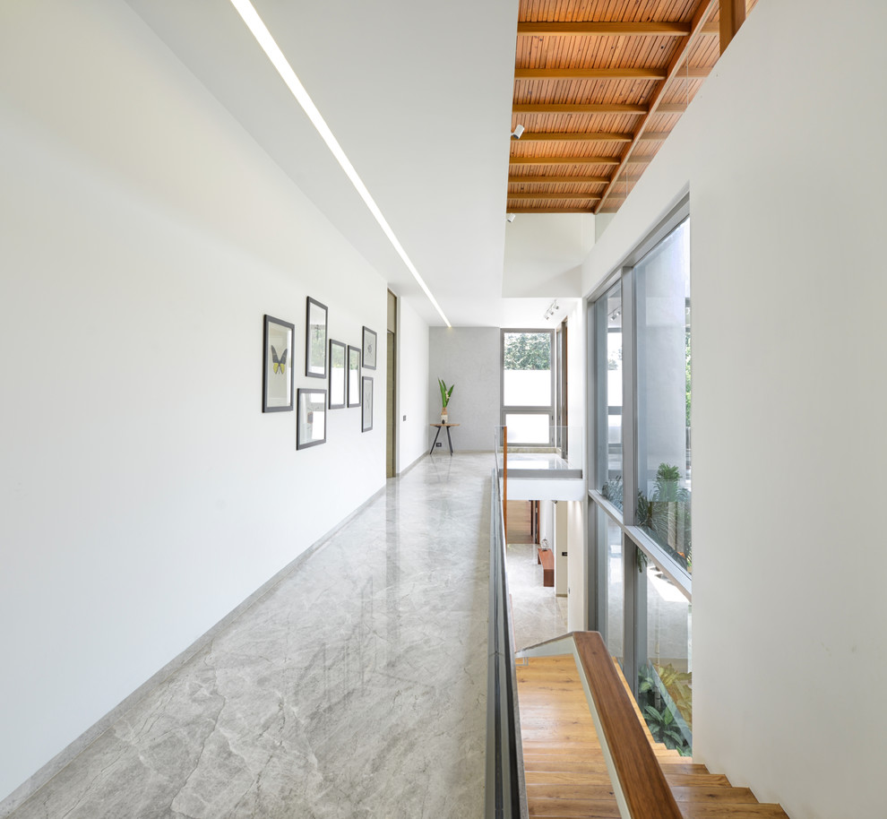 Esempio di un ingresso o corridoio minimal con pareti bianche, pavimento in cemento e pavimento grigio