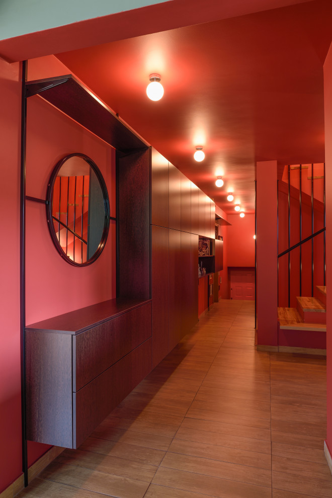 60 tals inredning av en stor hall, med ljust trägolv, brunt golv och röda väggar