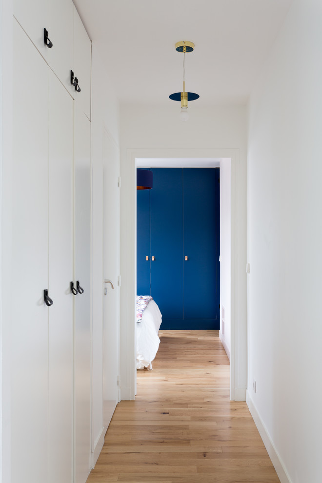 Idée de décoration pour un couloir tradition de taille moyenne avec un mur blanc, parquet clair et un sol beige.