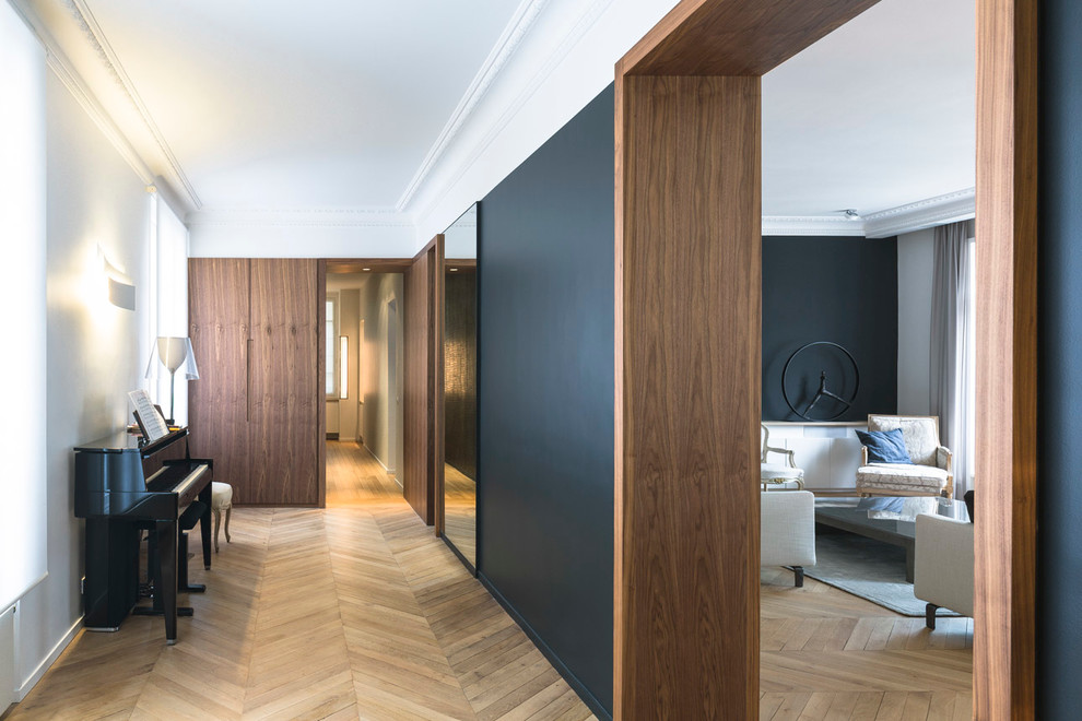Großer Moderner Flur mit schwarzer Wandfarbe und hellem Holzboden in Paris