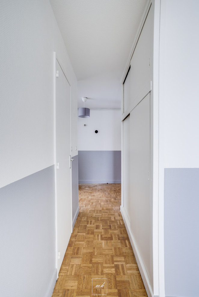 Idée de décoration pour un petit couloir minimaliste avec un mur gris et parquet clair.
