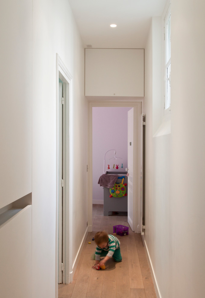 Idee per un ingresso o corridoio minimal di medie dimensioni con pareti bianche e pavimento in legno massello medio