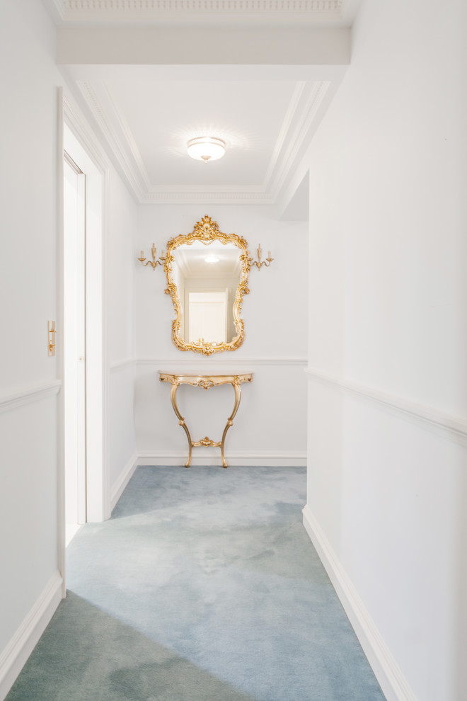 Пример оригинального дизайна: коридор среднего размера: освещение в стиле неоклассика (современная классика) с белыми стенами, ковровым покрытием и синим полом
