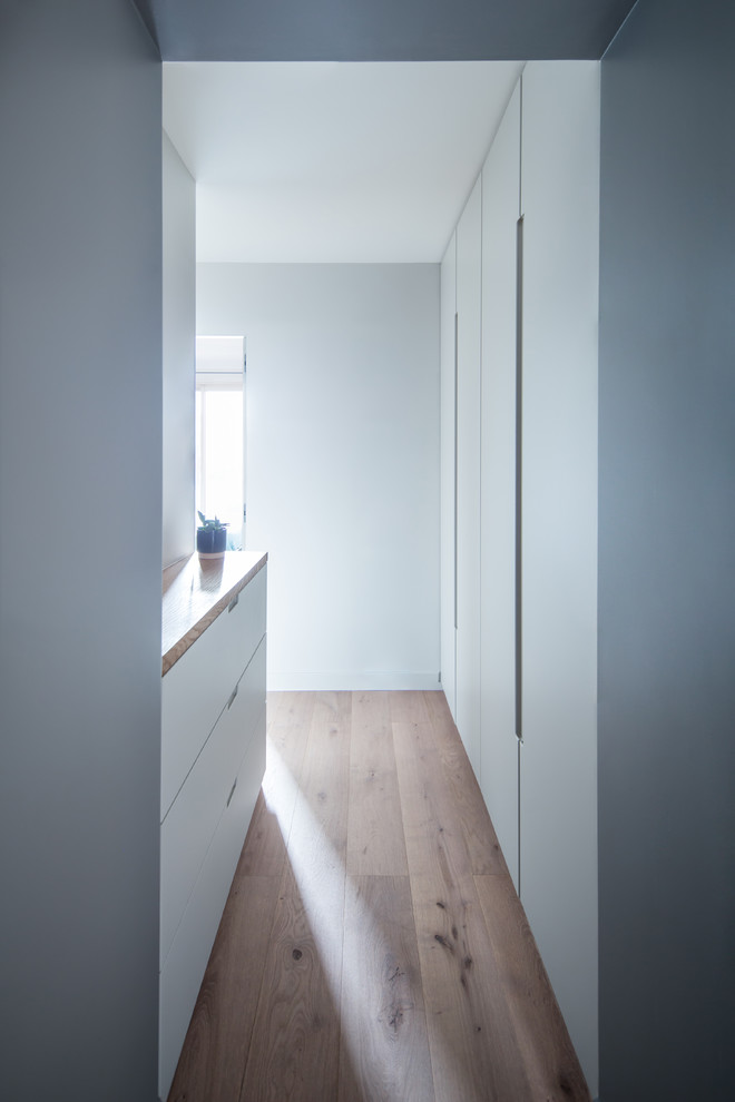 На фото: коридор среднего размера в скандинавском стиле с серыми стенами, паркетным полом среднего тона и коричневым полом