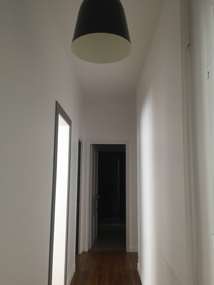 Exemple d'un couloir tendance de taille moyenne avec un mur blanc, parquet foncé, un sol bleu, un plafond en lambris de bois et boiseries.