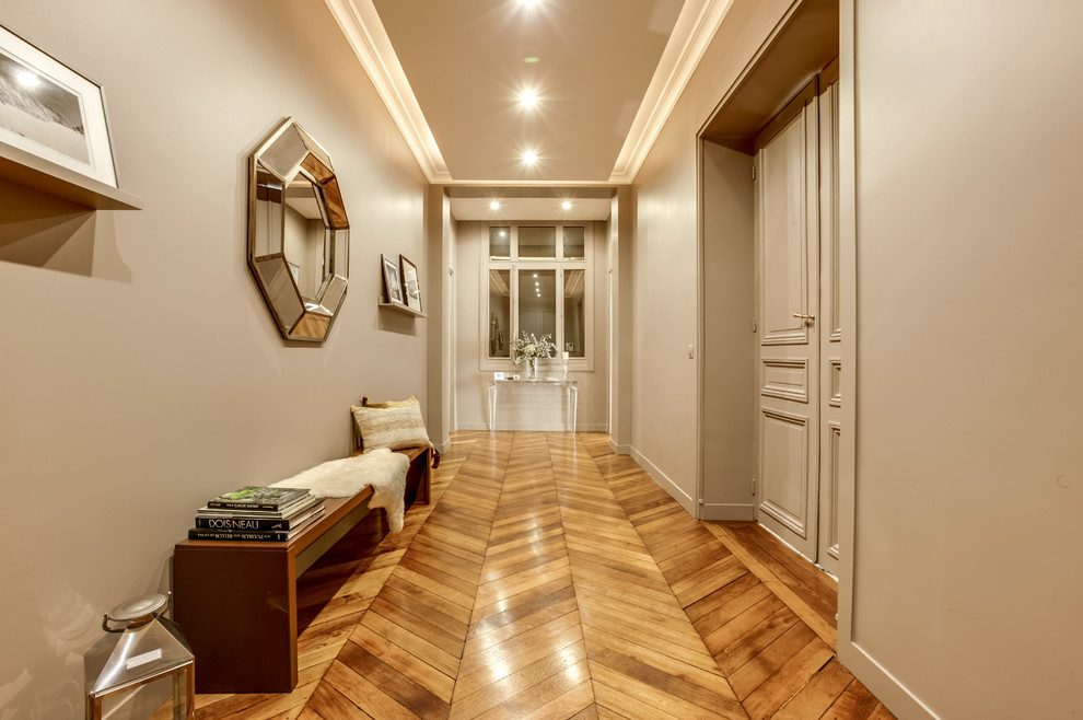 Hallway - large modern medium tone wood floor and brown floor hallway idea in Paris with gray walls