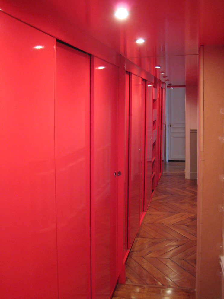 Kleiner Moderner Flur mit roter Wandfarbe und dunklem Holzboden in Paris