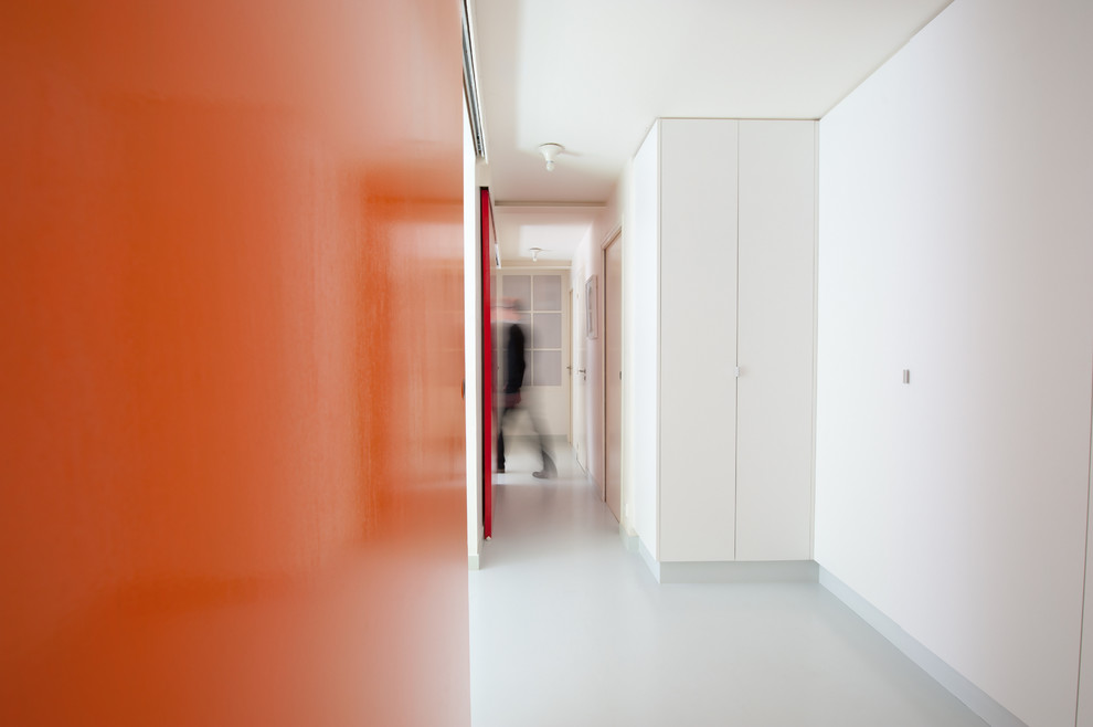 Réalisation d'un couloir de taille moyenne avec un mur blanc et parquet peint.