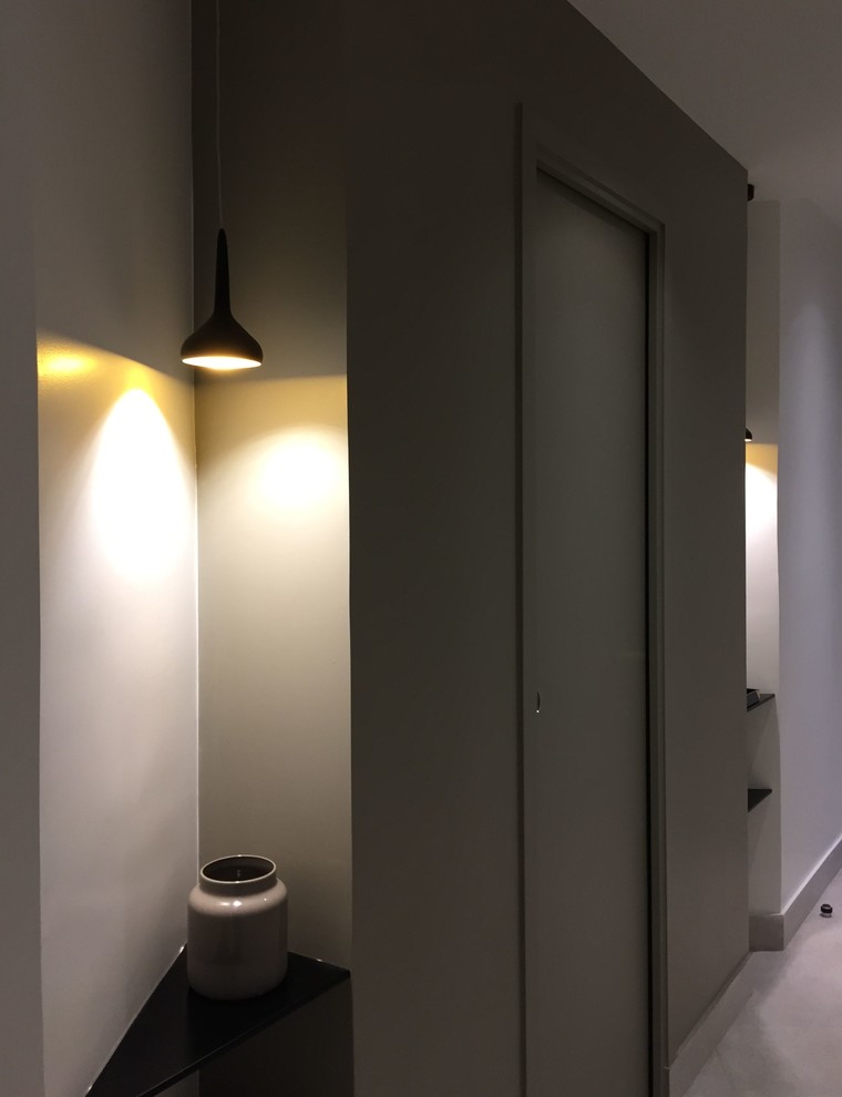 На фото: коридор среднего размера в современном стиле с полом из керамической плитки, белыми стенами и серым полом