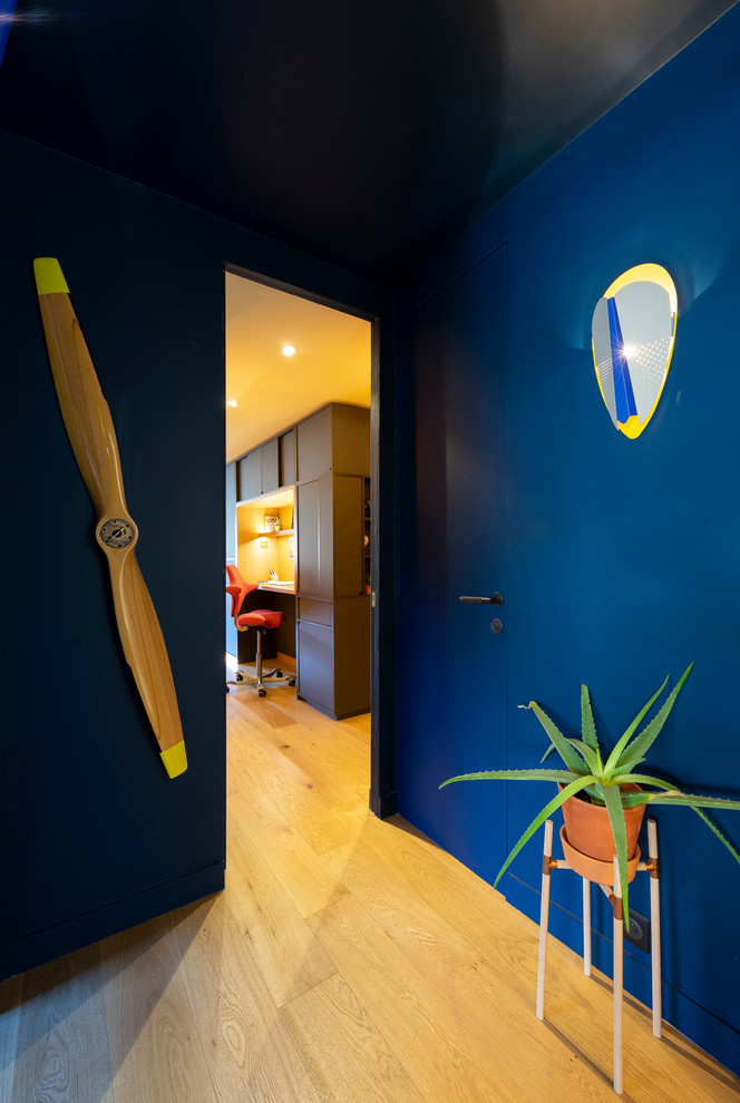 Esempio di un piccolo ingresso o corridoio minimalista con pareti blu, parquet chiaro e pavimento marrone