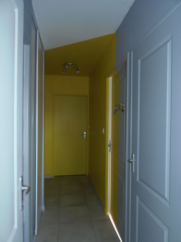 Bild på en skandinavisk hall, med gula väggar och grått golv
