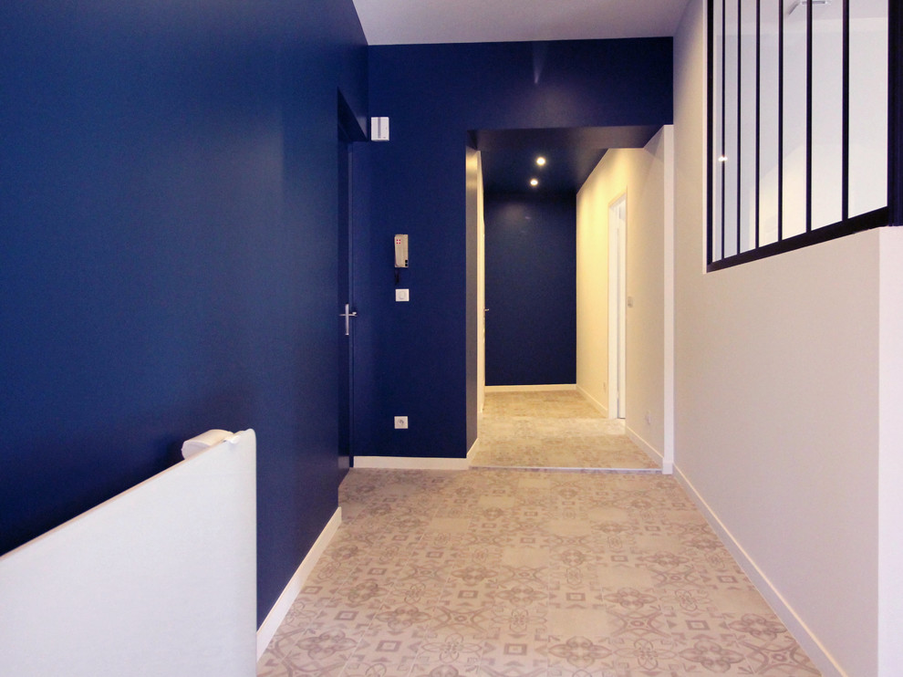 Aménagement d'un grand couloir contemporain avec un mur bleu et un sol en carrelage de céramique.