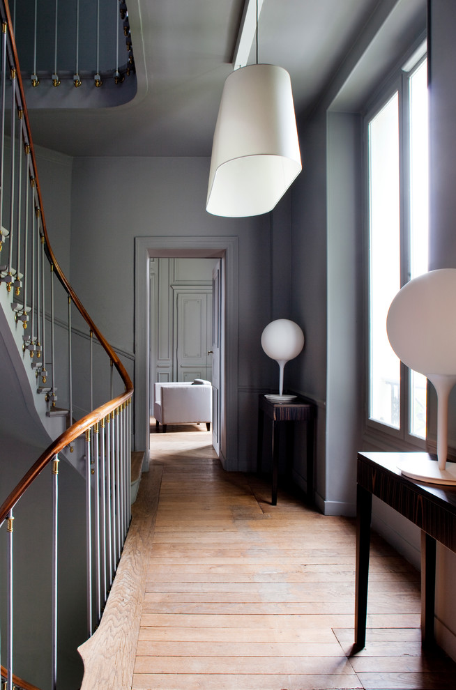 Пример оригинального дизайна: коридор среднего размера: освещение в современном стиле с серыми стенами и паркетным полом среднего тона
