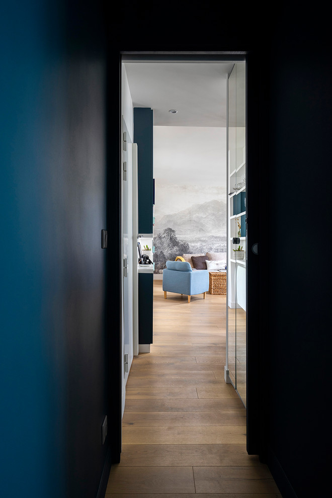 Immagine di un piccolo ingresso o corridoio con pareti blu e pavimento in legno massello medio