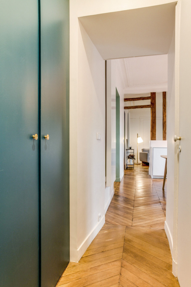 Idée de décoration pour un couloir design de taille moyenne avec un mur vert, parquet clair et un sol marron.