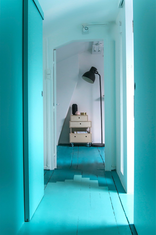 パリにある高級な中くらいな北欧スタイルのおしゃれな廊下 (青い壁、塗装フローリング) の写真