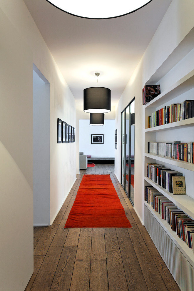 Esempio di un grande ingresso o corridoio con pareti bianche e pavimento in legno massello medio