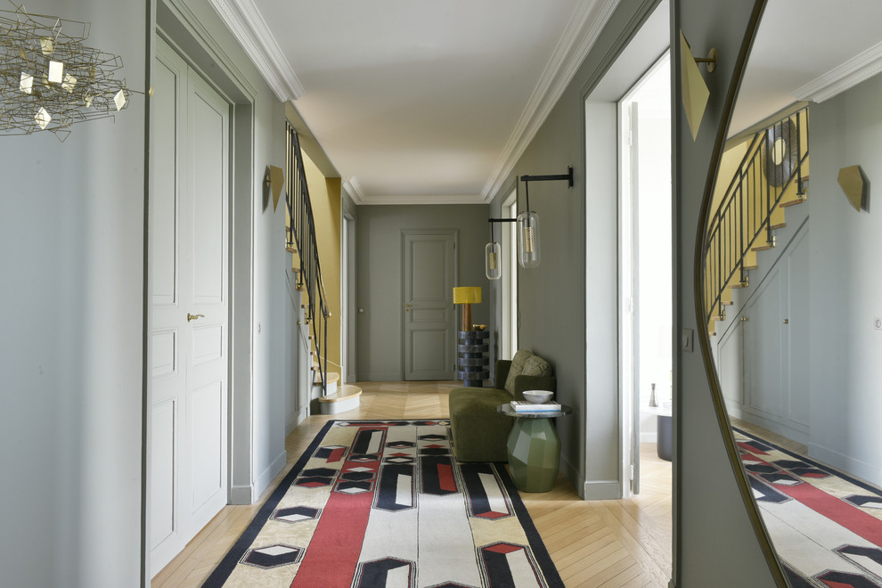 Idée de décoration pour un grand couloir tradition avec un mur gris, parquet clair et un sol marron.