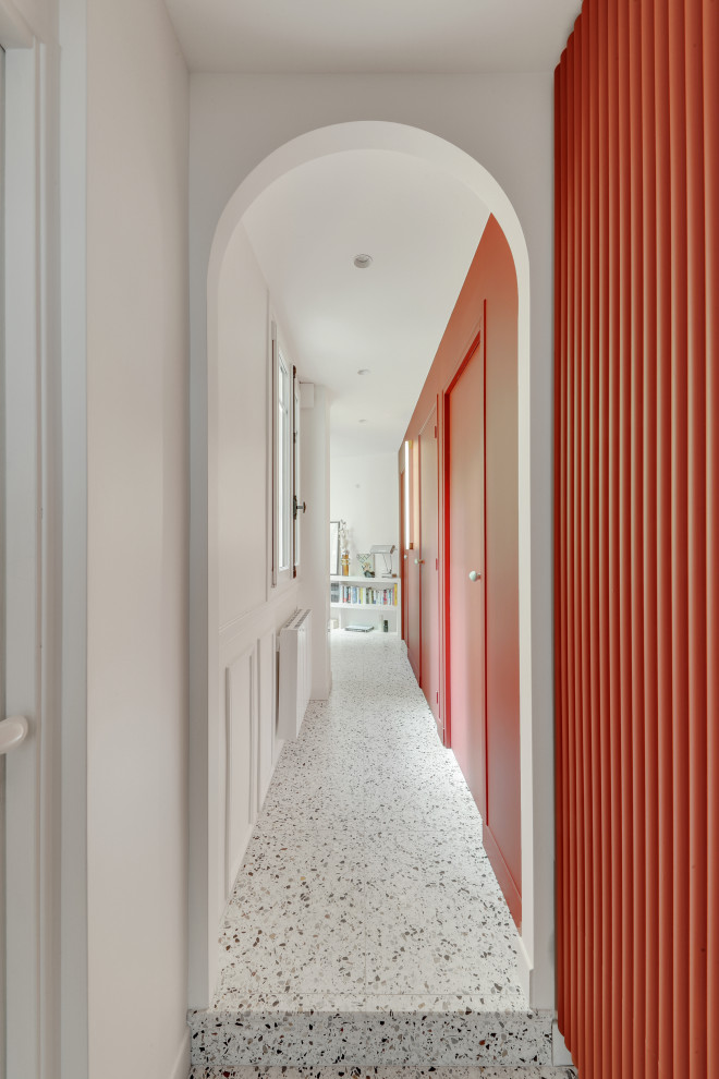 Exempel på en modern hall, med röda väggar, terrazzogolv och vitt golv
