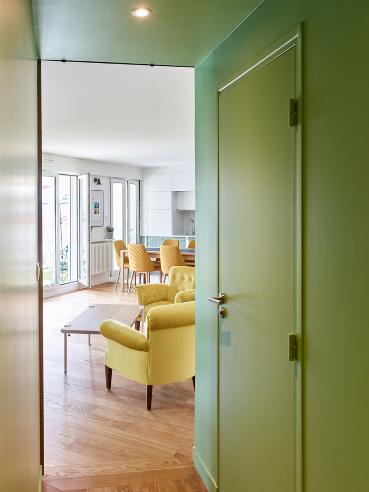 Ispirazione per un ingresso o corridoio design di medie dimensioni con pareti verdi, parquet chiaro e pavimento marrone