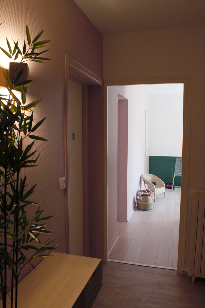 На фото: маленький коридор в стиле модернизм с розовыми стенами, полом из ламината и коричневым полом для на участке и в саду