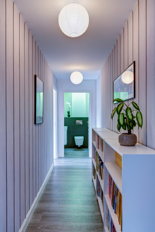 Cette image montre un couloir design de taille moyenne avec un mur blanc et parquet clair.
