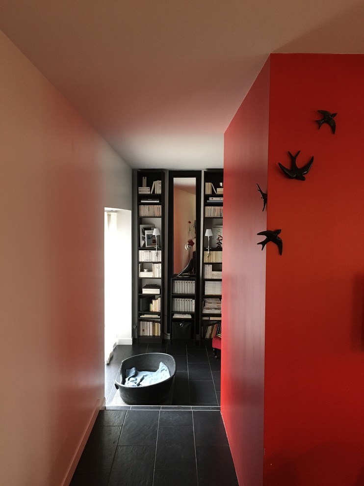 Imagen de recibidores y pasillos minimalistas de tamaño medio con paredes rojas, suelo de pizarra y suelo negro