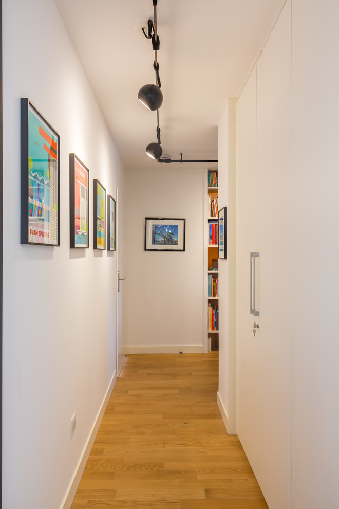 Mid-century modern medium tone wood floor and brown floor hallway photo in Bordeaux with white walls