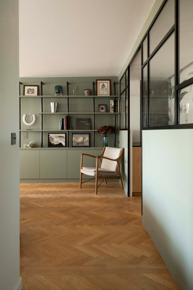 Foto de recibidores y pasillos minimalistas de tamaño medio con paredes verdes, suelo de madera clara y suelo beige