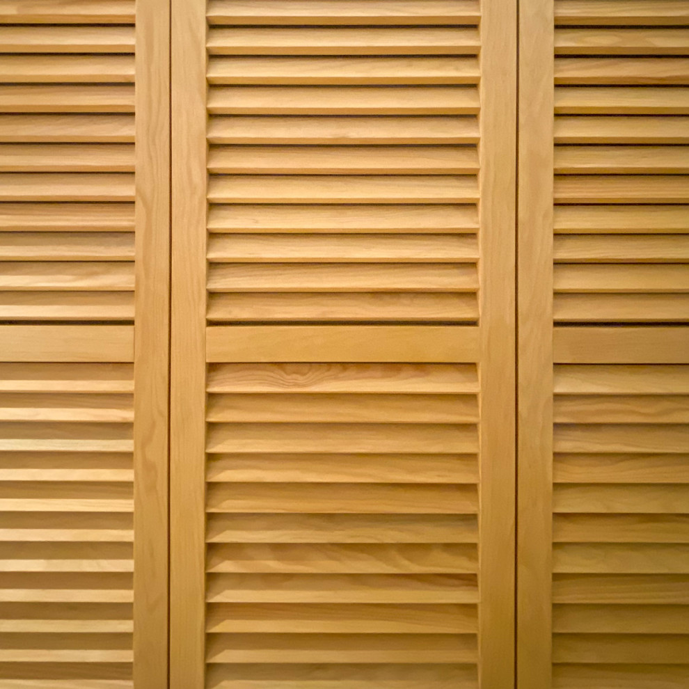 Cette photo montre un petit placard dressing tendance en bois clair neutre avec un placard à porte persienne, parquet clair, un sol marron et poutres apparentes.