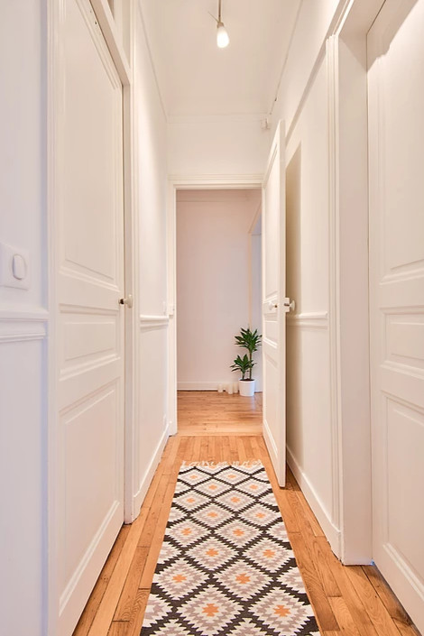 パリにある低価格の小さなコンテンポラリースタイルのおしゃれな廊下 (白い壁、無垢フローリング、茶色い床) の写真