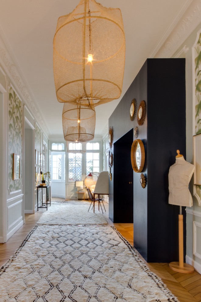Inspiration for an eclectic medium tone wood floor and brown floor hallway remodel in Paris with white walls