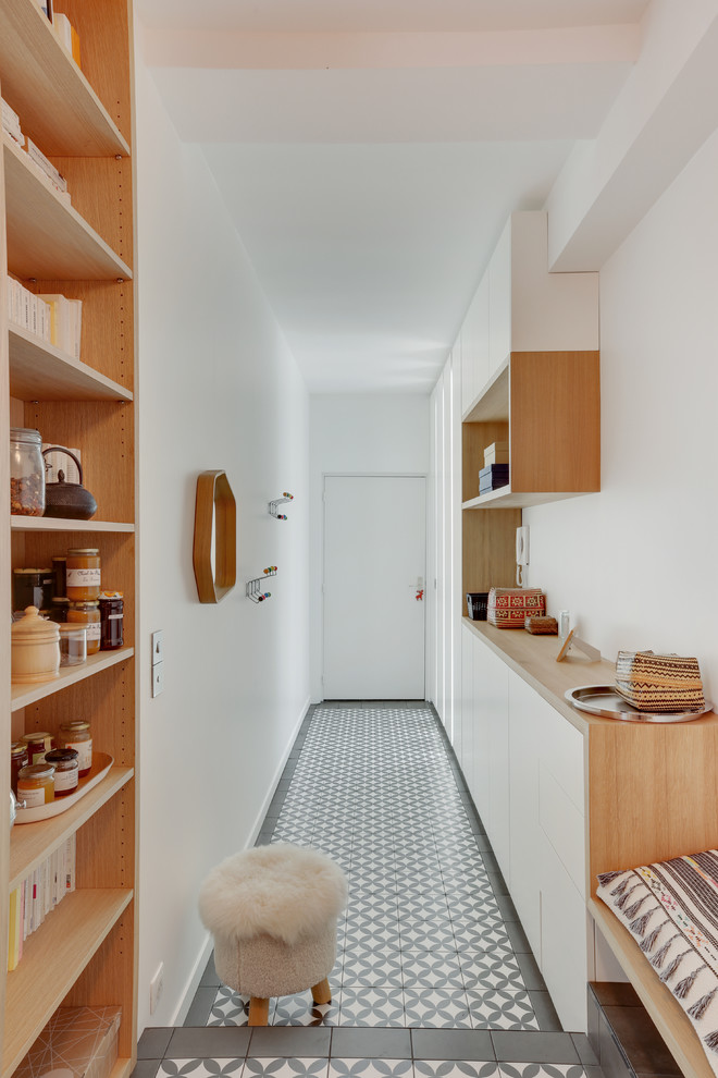 Cette image montre un couloir design de taille moyenne avec un mur blanc, tomettes au sol et un sol noir.