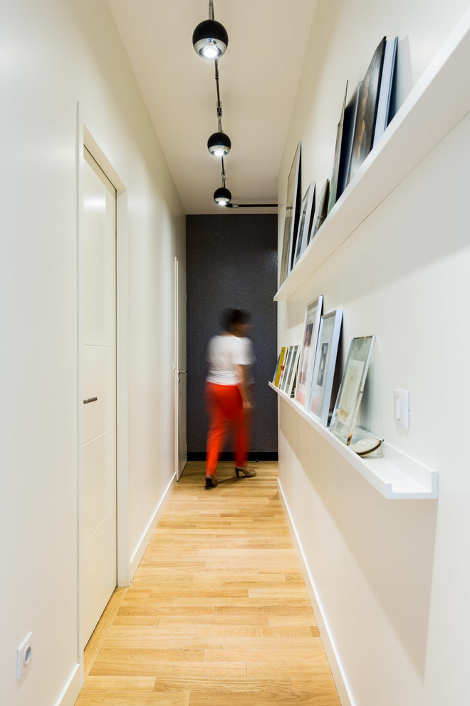 Aménagement d'un couloir contemporain de taille moyenne avec un mur blanc et parquet clair.