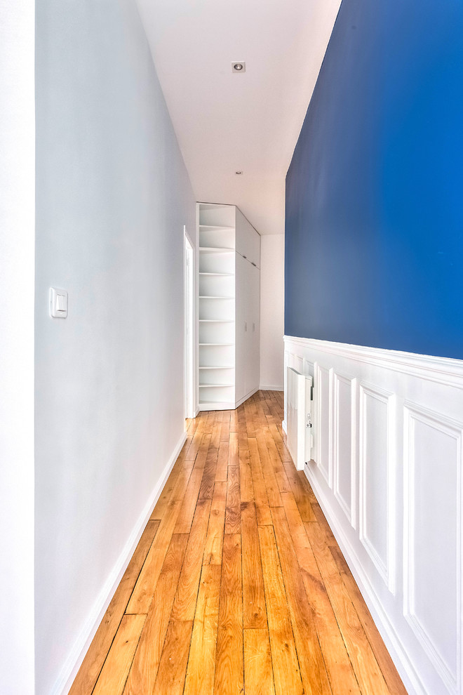На фото: большой коридор в классическом стиле с синими стенами, паркетным полом среднего тона и коричневым полом