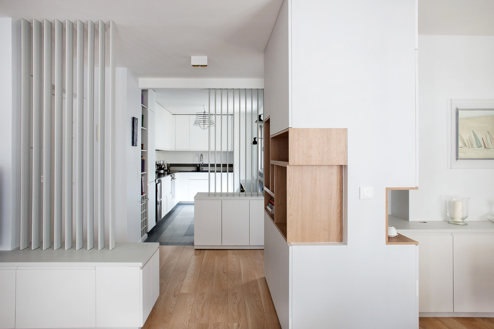 Inspiration pour un couloir design de taille moyenne avec un mur blanc et un sol en bois brun.