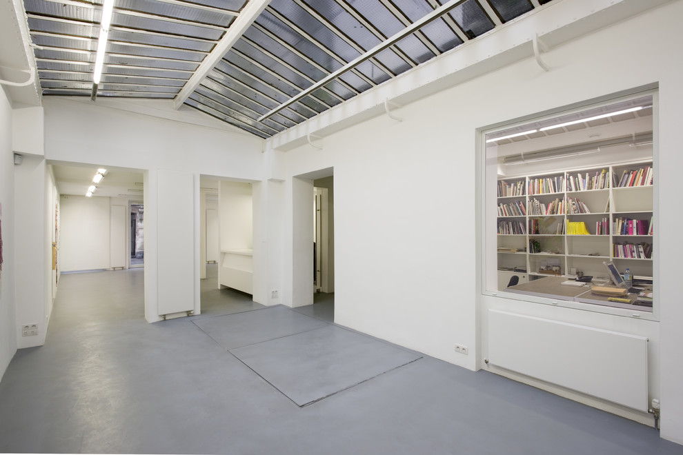 Идея дизайна: большой коридор в современном стиле с белыми стенами, бетонным полом и серым полом