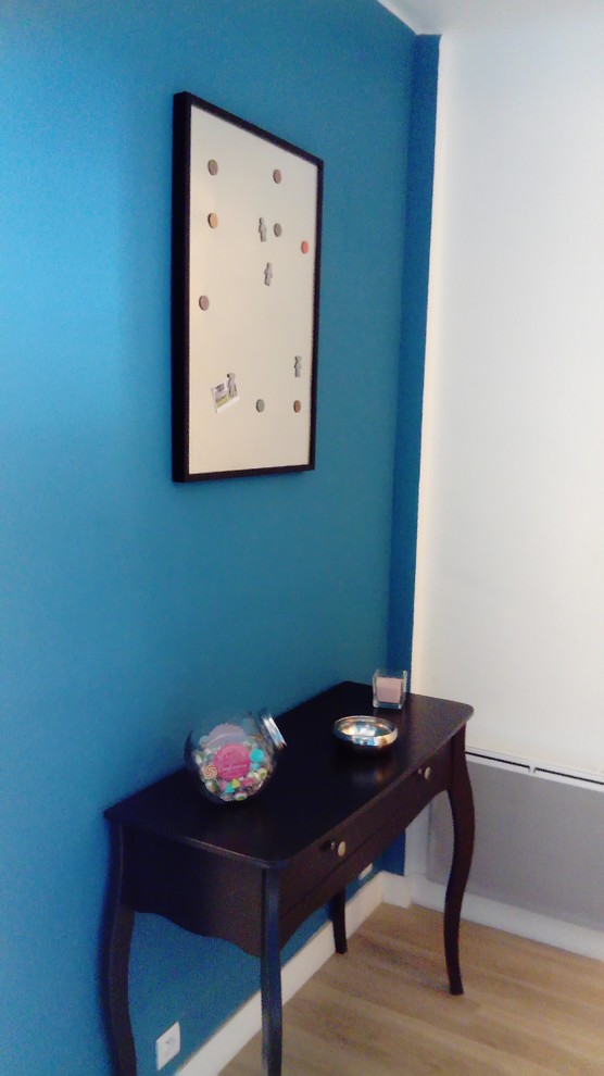 Foto de recibidores y pasillos minimalistas de tamaño medio con paredes azules, suelo laminado y suelo beige