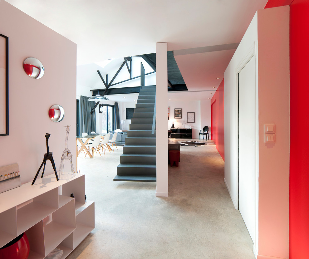 Ispirazione per un ingresso o corridoio minimal di medie dimensioni con pareti rosse e pavimento in cemento