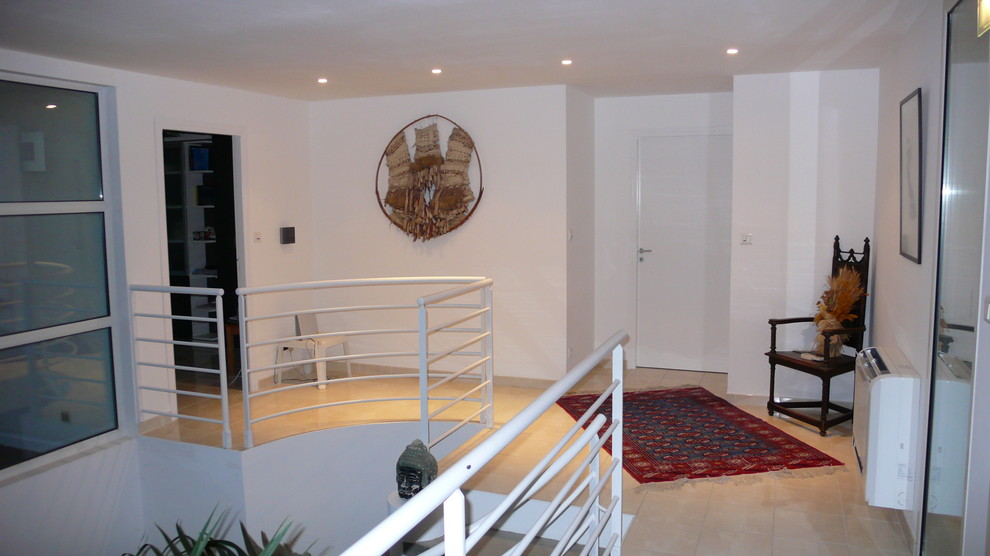 На фото: большой коридор в современном стиле с белыми стенами, полом из керамической плитки и бежевым полом
