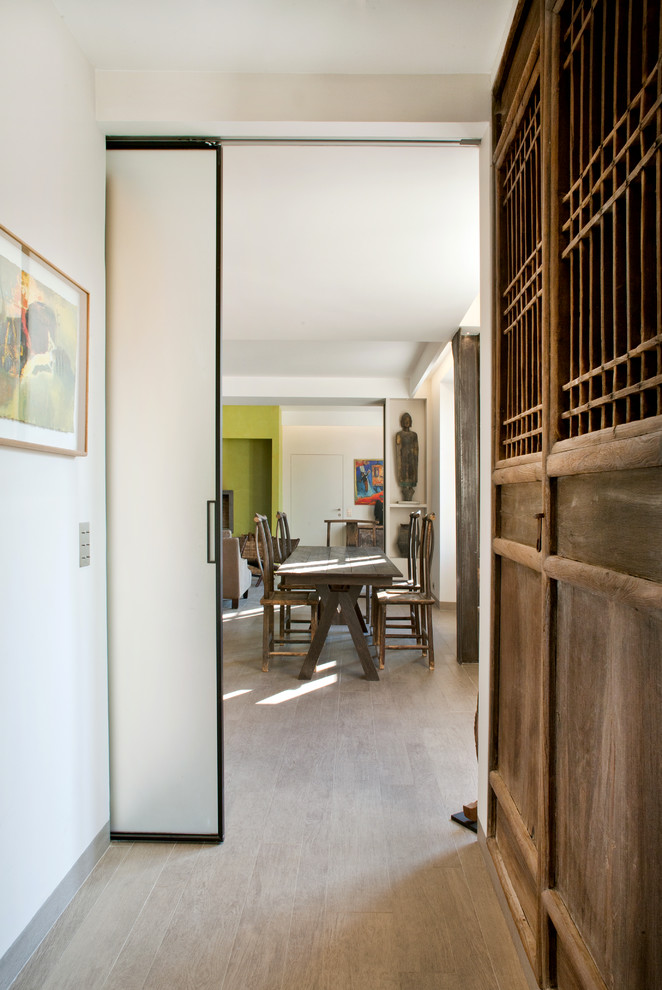 Example of an eclectic laminate floor and beige floor hallway design in Paris with white walls