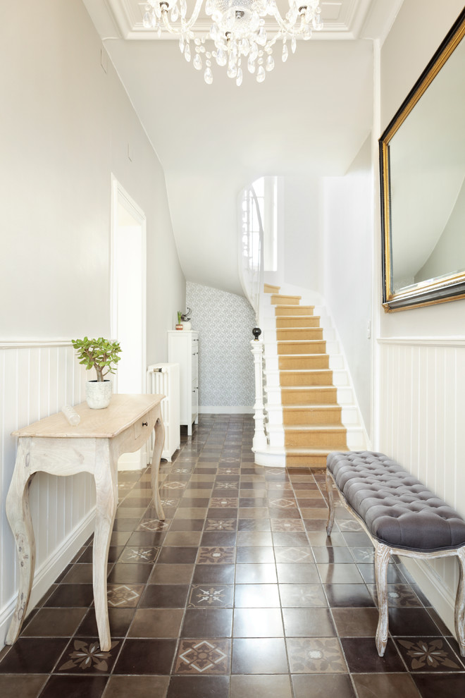 Idées déco pour un couloir classique de taille moyenne avec un mur gris, un sol marron et un sol en carrelage de céramique.