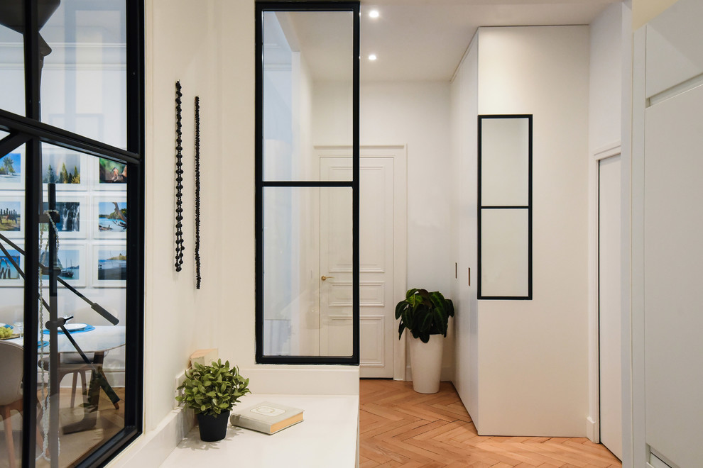 Стильный дизайн: коридор в современном стиле с белыми стенами, светлым паркетным полом и бежевым полом - последний тренд