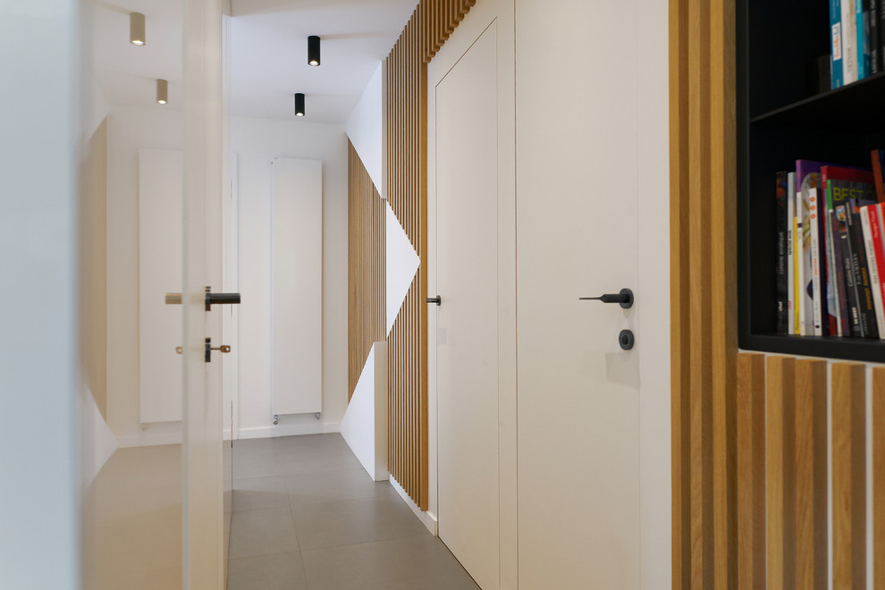 Diseño de recibidores y pasillos minimalistas de tamaño medio con paredes blancas, suelo de baldosas de cerámica y suelo gris